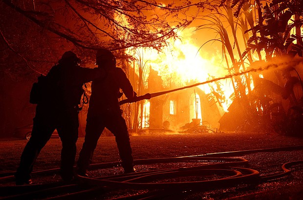 Los Angeles County firefighters spray water on a burning home as the Eaton Fire moved through the area on January 8 in Altadena, California.
Mandatory Credit:	Justin Sullivan/Getty Images via CNN Newsource