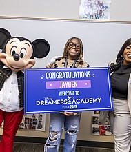 Mickey Mouse and Walt Disney World Ambassador Shannon-Smith Conrad pose with Alief Taylor High School (Houston, TX) student Jayden Kelly moments after she was surprised on January 13, 2025, with the news that she is one of 100 students selected for this year’s Disney Dreamers Academy at Walt Disney World Resort in Florida in March. Disney Dreamers Academy, in its 18th year, is an educational mentorship program that is fostering the career dreams of high school students from varying backgrounds and communities nationwide. (Christian Thompson)