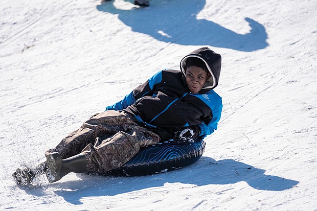 Twelve-year-old Kayin Ogunbunmi makes the most of the snow from a storm that hit Sunday, Jan. 12. He, along with his fellow snow enthusiasts, used the slope in Forest Hill Park for some sledding fun.