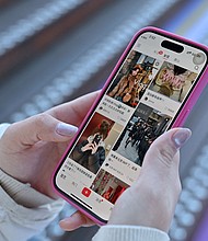 A woman scrolls the Chinese social networking and e-commerce app Xiaohongshu, also known as RedNote, in Beijing on January 15. The app has taken off in the United States ahead of the likely ban of TikTok.
Mandatory Credit:	Adek Berry/AFP/Getty Images via CNN Newsource