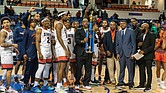 Virginia State Trojans celebrate their hard-fought 78-74 victory over Virginia Union in the Freedom Classic, hoisting the trophy as coaches, players, and cheerleaders share the moment of triumph.