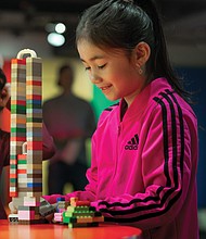 A young visitor builds a tower, previewing the interactive aspect of “Towers of Tomorrow with Lego Bricks,” opening Feb. 1 at the Science Museum of Virginia. The exhibit features iconic skyscrapers and hands-on creativity with more than 200,000 building bricks.