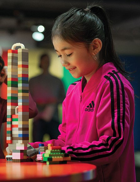 A young visitor builds a tower, previewing the interactive aspect of “Towers of Tomorrow with Lego Bricks,” opening Feb. 1 at the Science Museum of Virginia. The exhibit features iconic skyscrapers and hands-on creativity with more than 200,000 building bricks.