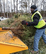 Jesse Hendren, of the City of Richmond Department of Public Works, loads a wood chipper with Christmas trees during the “Bring One for the Chipper” recycling event Saturday at 1710 Robin Hood Road. More than 1,000 trees were expected to be broken down during the event, where paper and electronics also were accepted for recycling.