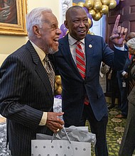 Delegate Don Scott, speaker of the Virginia House of Delegates, presents a birthday gift to former Gov. L. Douglas Wilder during the General Assembly’s recognition of the 40th anniversary of his historic election as Virginia’s first African American lieutenant governor. The
presentation took place in the House of Delegates and Senate chambers Friday, Jan. 17, coinciding with Wilder’s 94th birthday.