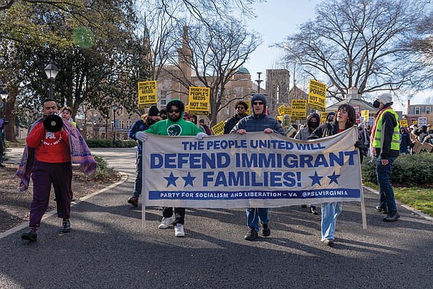 Protesters march in Monroe Park on Dr. Martin Luther King Jr. Day, carrying banners and chanting in solidarity with immigrant families during the “We Fight Back” protest, held in response to President Trump’s second inauguration and part of a nationwide call to action.