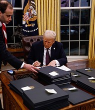 President Donald Trump signs executive orders in the Oval Office on Monday, including one to end DEI programs.
Mandatory Credit:	Anna Moneymaker/Getty Images via CNN Newsource