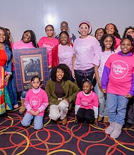 Sherri Shepherd (front left) and Ebony Obsidian (kneeling) pose with young girls who attended the screening for The Six Triple Eight at AMC Magic Johnson Harlem