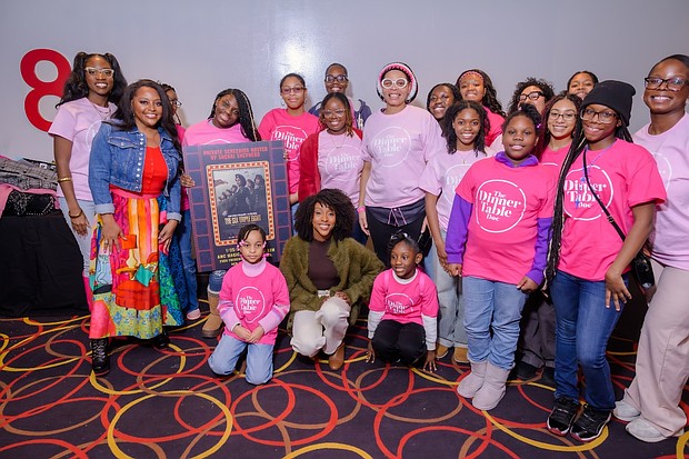 Sherri Shepherd (front left) and Ebony Obsidian (kneeling) pose with young girls who attended the screening for The Six Triple Eight at AMC Magic Johnson Harlem