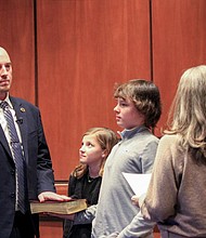 John Murray takes the oath of office as superintendent of Chesterfield County Public Schools, joined by his children, Emerson and Grant.