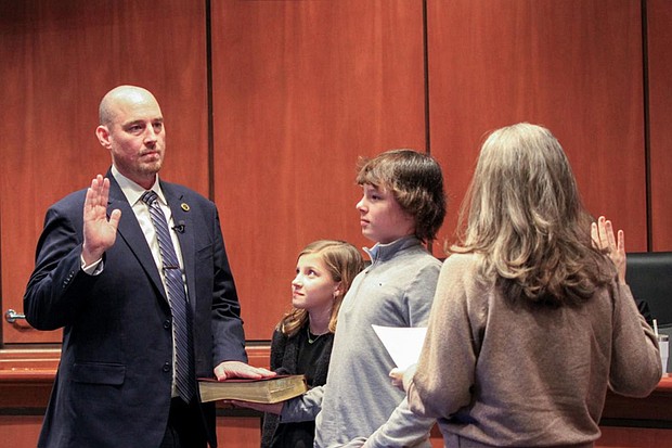 John Murray takes the oath of office as superintendent of Chesterfield County Public Schools, joined by his children, Emerson and Grant.
