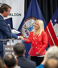 Gov. Glenn Youngkin presents a state flag to Lisa Paley, Haleon North America president, at a press conference on Jan 27. Haleon, a global consumer health company, announced it will invest $54.2 million to upgrade its research and development facility in Richmond.
