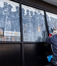 Installation of “Portals,” a public art project, began Wednesday morning, Jan. 29. Featuring 20 large-scale historic photographs displayed in windows throughout Shockoe Bottom, the installation celebrates the legacy, resilience and everyday lives of African American Richmonders from the early 1800s to the 1980s. The project, installed by Mike Murphy and John McLeod of Three One One Printing, is set to be completed on Thursday, Jan. 30.