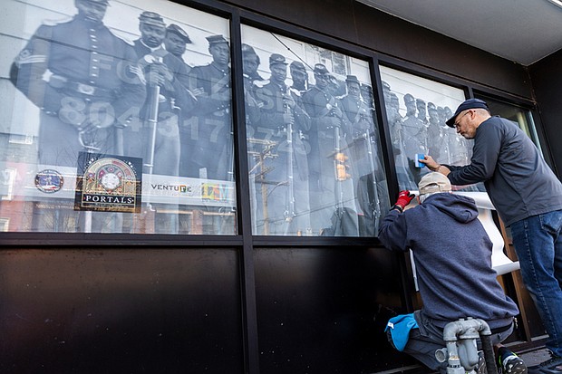 Installation of “Portals,” a public art project, began Wednesday morning, Jan. 29. Featuring 20 large-scale historic photographs displayed in windows throughout Shockoe Bottom, the installation celebrates the legacy, resilience and everyday lives of African American Richmonders from the early 1800s to the 1980s. The project, installed by Mike Murphy and John McLeod of Three One One Printing, is set to be completed on Thursday, Jan. 30.