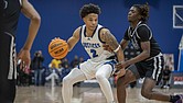 John Marshall’s Troy Henderson looks for an opening against Woodside’s defense during the Coaches 4 The Cure event at the Henrico Sports & Event Center on Saturday. The Justices edged Woodside 50-47 in the marquee matchup. Richmond Free Press/Julianne Tripp Hillian