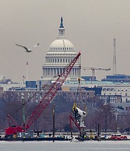 A crane retrieves a piece of wreckage Monday from the Potomac River in the aftermath of the collision of American Eagle flight 5342 and a Black Hawk helicopter that crashed into the river.
Mandatory Credit:	Nathan Howard/Reuters via CNN Newsource