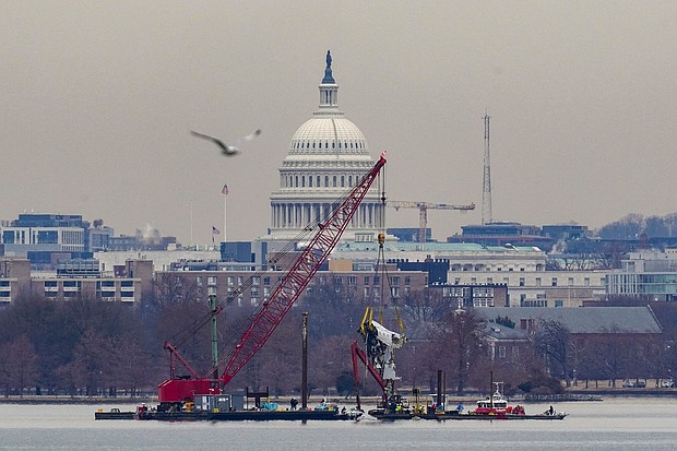A crane retrieves a piece of wreckage Monday from the Potomac River in the aftermath of the collision of American Eagle flight 5342 and a Black Hawk helicopter that crashed into the river.
Mandatory Credit:	Nathan Howard/Reuters via CNN Newsource