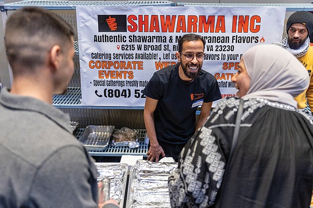 Bashar (left) and Hasan (right) greet customers at the Shawarma Inc. booth, where they serve a variety of authentic shawarma and Mediterranean foods.