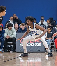 Latrell Allmond defends during the John Marshall game against Woodside at the 13th Annual Coaches for the Cure High School Basketball Showcase, where he scored 17 points and hit the game-winning shot in the final seconds, leading the Justices to a 50-47 victory.