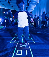 Four-year-old Dakari G. plays hopscotch during the Science Museum of Virginia’s Glow event.