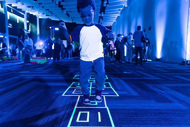 Four-year-old Dakari G. plays hopscotch during the Science Museum of Virginia’s Glow event.