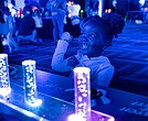 Sarai, 2, interacts with a glow-in-the-dark display at the Science Museum of Virginia.