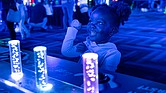 Sarai, 2, interacts with a glow-in-the-dark display at the Science Museum of Virginia.