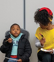 Danielle Freeman Jefferson, a farmer at Gilpin Court Restorative Garden, chats with Habakkuk Aziz Jr. about his favorite honeys during the tasting. Habakkuk was accompanied by his parents, Habakkuk Aziz Sr. and Sis Aziz.