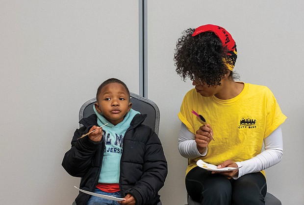 Danielle Freeman Jefferson, a farmer at Gilpin Court Restorative Garden, chats with Habakkuk Aziz Jr. about his favorite honeys during the tasting. Habakkuk was accompanied by his parents, Habakkuk Aziz Sr. and Sis Aziz.
