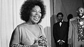 Roberta Flack holds the Grammy award for her record, “Killing Me Softly With His Song” as singer Isaac Hayes, right, looks on at the Grammy Awards in Los Angeles on March 4, 1974.