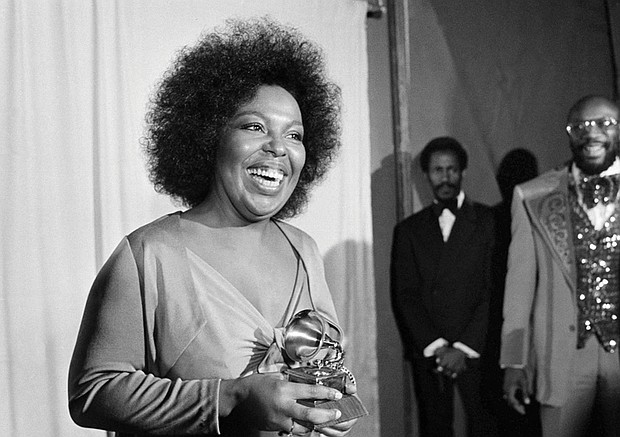Roberta Flack holds the Grammy award for her record, “Killing Me Softly With His Song” as singer Isaac Hayes, right, looks on at the Grammy Awards in Los Angeles on March 4, 1974.