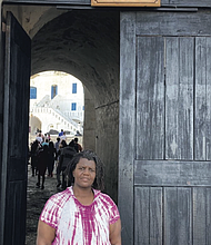 Morgan McCommons, assistant professor of history and Africana studies at the University of Richmond, stands at the “Door of Return” at Cape Coast Castle in Ghana, a symbolic passage marking the reconnection of the African diaspora with their ancestral homeland.