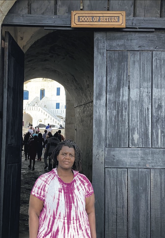 Morgan McCommons, assistant professor of history and Africana studies at the University of Richmond, stands at the “Door of Return” at Cape Coast Castle in Ghana, a symbolic passage marking the reconnection of the African diaspora with their ancestral homeland.