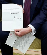 US President Donald Trump holds a letter from Britain's King Charles as he meets with British Prime Minister Keir Starmer in the Oval Office on February 27.
Mandatory Credit:	Kevin Lamarque/Reuters via CNN Newsource