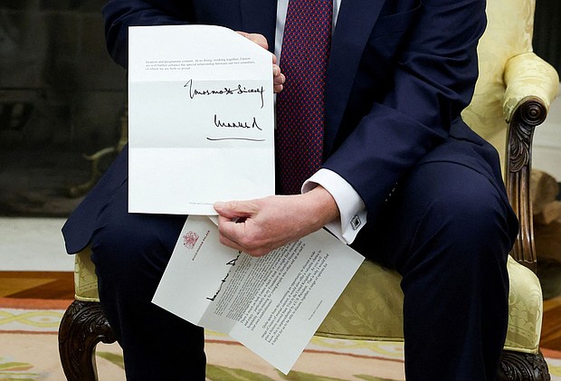 US President Donald Trump holds a letter from Britain's King Charles as he meets with British Prime Minister Keir Starmer in the Oval Office on February 27.
Mandatory Credit:	Kevin Lamarque/Reuters via CNN Newsource