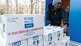 City workers unload cases of emergency drinking water Jan. 7 at Pine Camp Community Center. The site was one of 10 water distribution locations set up after a boil water advisory was issued following a storm-related outage that caused a failure at the water treatment facility.