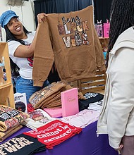 Ebony Blake of E Boutique shows customers one of her sweatshirts at the Black AF event on Friday, Feb. 28, at Diversity Richmond.