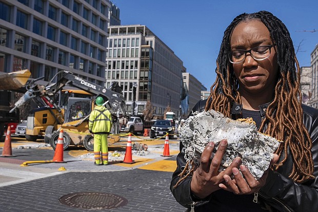 Tears roll down the face of Starlette Thomas, of Bowie, Md., as she holds a chunk of pavement from the Black Lives Matter plaza, Monday, March 10, as the mural begins to be demolished in Washington. “I needed to be here to bear witness,” says Thomas, who was present at the 2020 George Floyd protests.