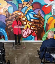 Gayle Turner, a first cousin of Bruce Oliver Tucker, the involuntary donor for Virginia’s first heart transplant in 1968, addresses attendees at VCU Health’s unveiling ceremony of a mural honoring Tucker March 5. The event included the renaming of the McGlothlin Medical Education Center auditorium in honor of Tucker and the unveiling of a mural displayed outside the renamed Bruce Oliver Tucker Auditorium. The mural was designed by Virginia Commonwealth University students Haley Salon, Yara Jeff and Zoe Jeweler, who collaborated with Tucker’s family and Richmond artist Hamilton Glass.