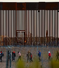 Migrants seeking asylum in the United States gather near the border wall after crossing a razor wire fence as a member of the Texas National Guard escorts them on December 19, 2024.
Mandatory Credit:	Jose Luis Gonzalez/Reuters/File via CNN Newsource