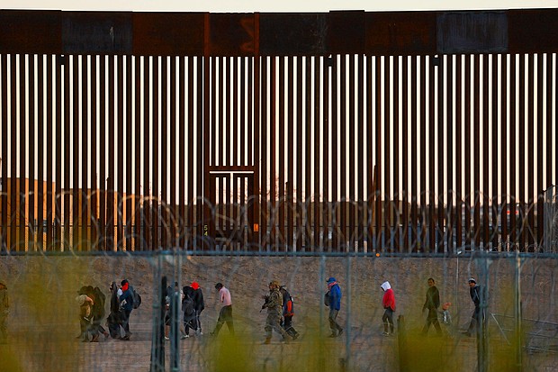 Migrants seeking asylum in the United States gather near the border wall after crossing a razor wire fence as a member of the Texas National Guard escorts them on December 19, 2024.
Mandatory Credit:	Jose Luis Gonzalez/Reuters/File via CNN Newsource