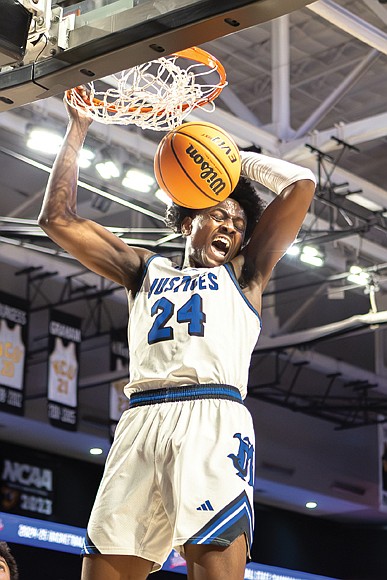 John Marshall’s Latrell Allmond (24) soars for a powerful dunk. The John Marshall Justices defeated the Graham G-Men 107-81 in the Class 2 VHSL State Finals on Thursday, March 13, at the Siegel Center.