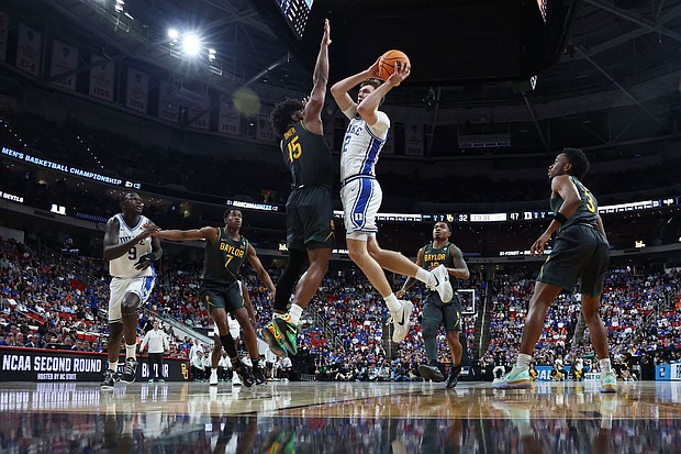 Duke's Cooper Flagg attempts a shot while guarded by Baylor's Norchad Omier during a March Madness second round game.
Mandatory Credit:	Jared C. Tilton/Getty Images via CNN Newsource