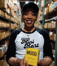 Brianna Arps, founder of Black-owned fragrance brand Moodeaux, holds her “Mini Mart" perfume in Atlanta on March 21, 2025. Her brand, carried by retailers like Urban Outfitters, faces new challenges as corporate DEI programs recede.