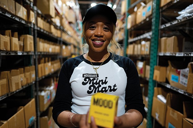 Brianna Arps, founder of Black-owned fragrance brand Moodeaux, holds her “Mini Mart" perfume in Atlanta on March 21, 2025. Her brand, carried by retailers like Urban Outfitters, faces new challenges as corporate DEI programs recede.