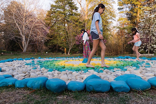 Hannah Bishop and her daughters, Salomé and Sol Perez, explore The Barefoot Circle, a circular rock garden created by their husband and father, artist Alfonso Pérez Acosta. The installation is part of the new exhibition “Homes & Habitats” at Lewis Ginter Botanical Garden, which continues through Sept. 28.