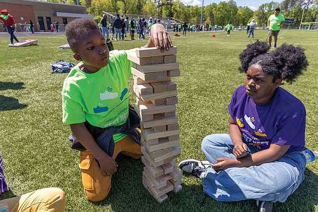 Boushall Middle School students Cali (right), a seventh-grader, and Dy’lon (left), a sixth-grader, face off in a game of Jenga.