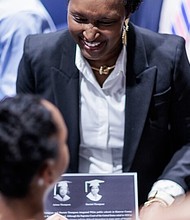 Faizah Hough shows a plaque honoring her mother, Harriett Thompson, to her daughter, Kaylen Hough 12, following a tribute to honor the first students to integrate Patrick Henry High School on Monday, April 14, 2025 in Hanover County. Shaban Athuman / VPM News