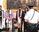 A police officer, right, stands near as the Rev. Jonathan Wilson-Hartgrove, from left, the Rev. William Barber II and others pray in the Capitol Rotunda, Monday, April 28, in Washington.