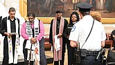 A police officer, right, stands near as the Rev. Jonathan Wilson-Hartgrove, from left, the Rev. William Barber II and others pray in the Capitol Rotunda, Monday, April 28, in Washington.